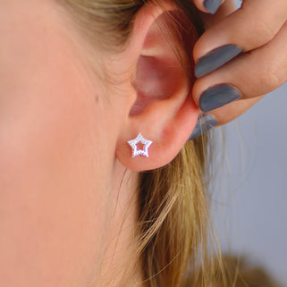 Sterling Silver CZ Open Star Stud Earrings shown close up on a model.