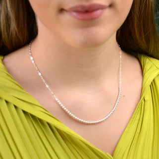 silver chain and pearl bead necklace shown in close up shot on model.