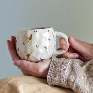 white stoneware mug with hand decorated details