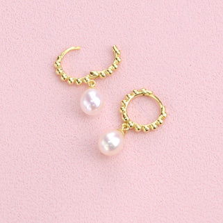 Gold beaded hoop earrings with pearl drops shown close  up  with hinged detail