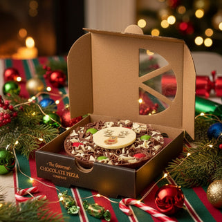 Chocolate pizza with a reindeer face in a branded box on a white background