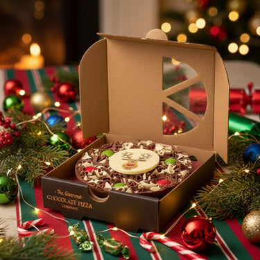Chocolate pizza with a reindeer face in a branded box on a white background