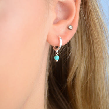 Sterling Silver Turquoise Dangle Huggie Earrings shown close up on model