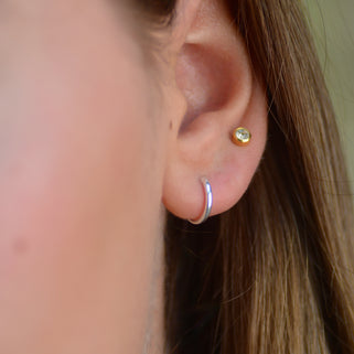 Simple Silver Sleeper Huggie Hoop Earrings  shown close up on model
