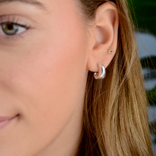 Sterling Silver Misshapen Huggie Hoop Earrings shown in close up shot on model