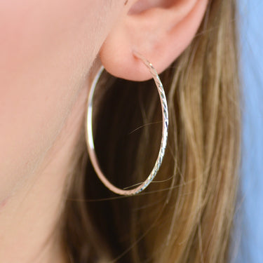 Sterling Silver Large Textured Hoop Earrings shown close up on model