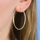 Sterling Silver Large Textured Hoop Earrings shown close up on model