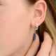 Silver open heart hoop earrings shown close up on model