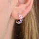 Silver open heart hoop earrings shown close up on model
