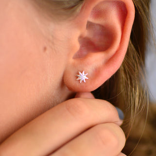 Sterling Silver Starburst Stud Earrings shown close up on model.