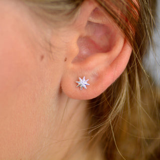 Sterling Silver Starburst Stud Earrings shown close up on model.
