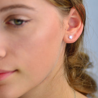 Sterling Silver Starburst Stud Earrings shown close up on model.