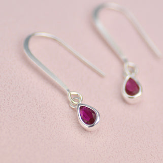 Sterling Silver Teardrop Birthstone Drop Earrings shown close up with January Birthstone