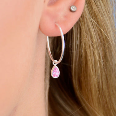 Sterling Silver Teardrop Birthstone Hoop Earrings shown close up with October birthstone