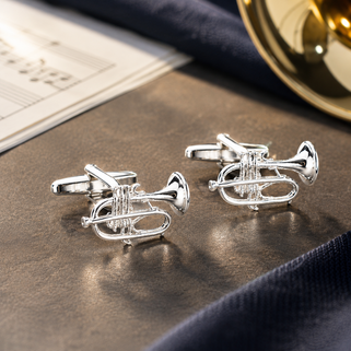 Silver trumpet-shaped cufflinks on a dark surface with a blurred background