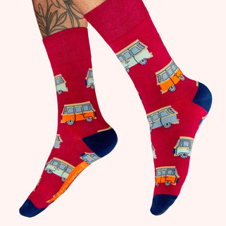 Red socks with camper van pattern worn by a person on a white background