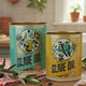 Two olive oil tins with decorative labels on a white background