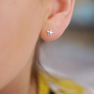 Silver Mini Starfish Studs shown in close up shot on model