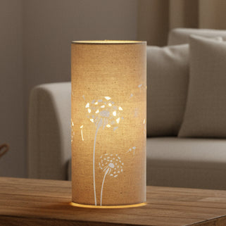 Decorative table lamp with dandelion design on a wooden surface.