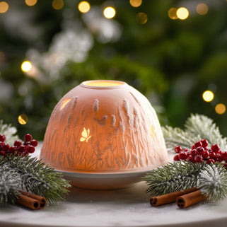 Decorative wax warmer with floral design on a table with Christmas decorations.