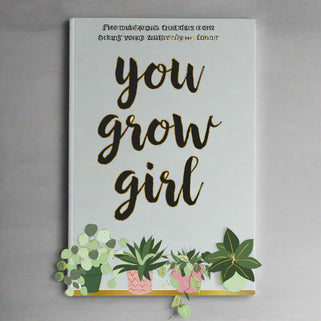 Cover of the book 'You Grow Girl' with a pink background, featuring gold lettering, small plants, and the tagline 'Empowering Quotes for Girls Who Are Wild & Free'.