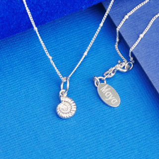 Sterling Silver Ammonite Charm on satellite chain necklace and personalised oval disc with "Maya" Engraved necklace shown in close up shot