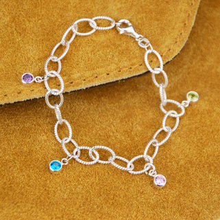 Personalised Family Birthstone Charm Bracelet - August/Peridot, June/Alexandrite, December/Blue Topaz, February/Amethyst, shown close up