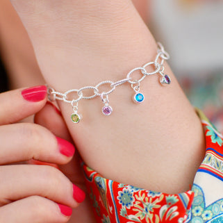 Personalised Family Birthstone Charm Bracelet - August/Peridot, June/Alexandrite, December/Blue Topaz, February/Amethyst, shown on model close up