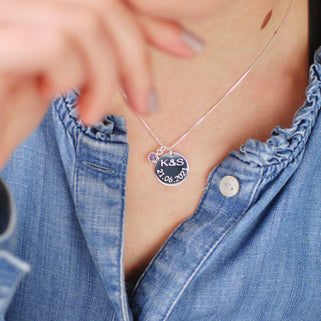 Sterling Silver Celebration Necklace. Silver round disc with "K&S 21.06.2021" engraved and February/Amethyst birthstone, shown in close up shot on model