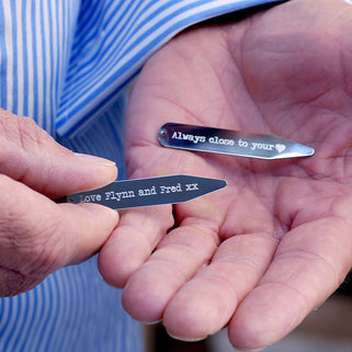 Silver collar stiffeners with "Always close to you heart" engraved on one and "Love Flynn and Fred" engraved on the other, shown in close up shot.