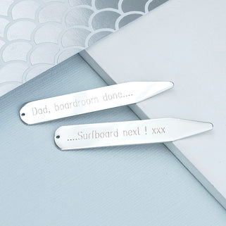 Silver collar stiffeners with "Dad, boardroom done..." engraved on one and "...surfboard next! xxx" engraved on the other, shown in close up shot.