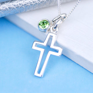 Silver cross charm necklace with August/Peridot birthstone charm, shown in close up shot