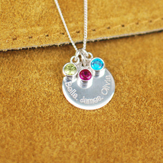 Personalised Family Names Birthstone Necklace - Silver engraved circle disc with "Bella, James, Olivia" and three birthstones  August/Peridot, December/Blue topaz,  July/Ruby shown close up