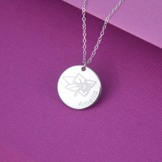 Silver circle disc necklace with March/Daffodil birth flower and "Amelia" engraved shown close up