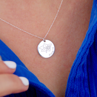Silver circle disc necklace with March/Daffodil birth flower and "Amelia" engraved shown close up