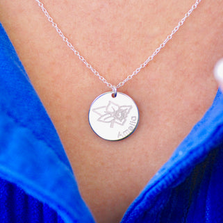 Silver circle disc necklace with March/Daffodil birth flower and "Amelia" engraved, shown on model close up