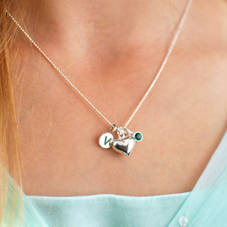 Sterling Silver Heart Necklace with V Initial disc and May Emerald birthstone shown close up on model