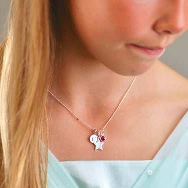 Sterling Silver Star Necklace with Initial C Disc and July Ruby birthstone charm shown close up on model