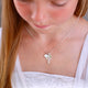 Girl's Sterling Silver Cross Necklace with S Initial Disc and August Peridot birth stone shown on model