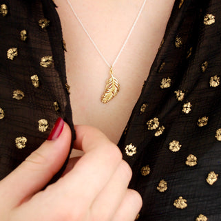 gold vermeil floating feather necklace shown in close up shot on model
