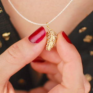 gold vermeil floating feather necklace shown in close up shot on model.
