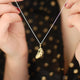 gold vermeil floating feather necklace shown in close up shot with model