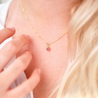 Personalised Gold Family Birthstone Necklace with Ruby/July Birthstone shown close up on model.