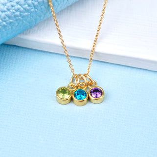 Personalised Gold Family Birthstone Necklace with three birthstones - August/Peridot, December/Blue Topaz, February/Amethyst shown close up