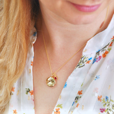 Gold vermeil hammered birthstone locket necklace show in close up on model.