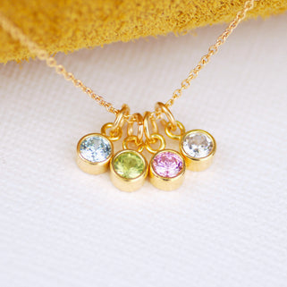 Personalised Gold Family Birthstone Necklace with four birthstones - April/Clear, August/Peridot,  June/Alexandrite and March/Aquamarine shown close up 