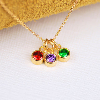 Personalised Gold Family Birthstone Necklace with three birthstones - July/Ruby, May/Emerald, February/Amethyst shown close up 