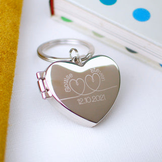 Silver heart locket keyring with infinity heart engraving with "Elouise" and "Steven" above and "12.10.2021" below.