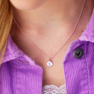 Sterling Silver E Initial Disc Necklace shown close up on model