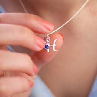Sterling Silver Script Initial "H" and September/Sapphire Birthstone Necklace shown in close up shot on model